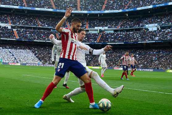 El defensor español del Real Madrid Sergio Ramos, desafía al mediocampista del Atlético de Madrid, el belga Yannick Carrasco durante el clásico madrileño. (Foto Prensa Libre: AFP)