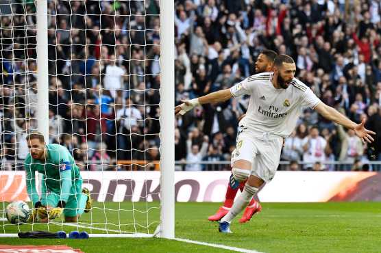 Karim Benzema celebra la anotación que le dio la victoria al Real Madrid en el derbi de la capital española. (Foto Prensa Libre: AFP)