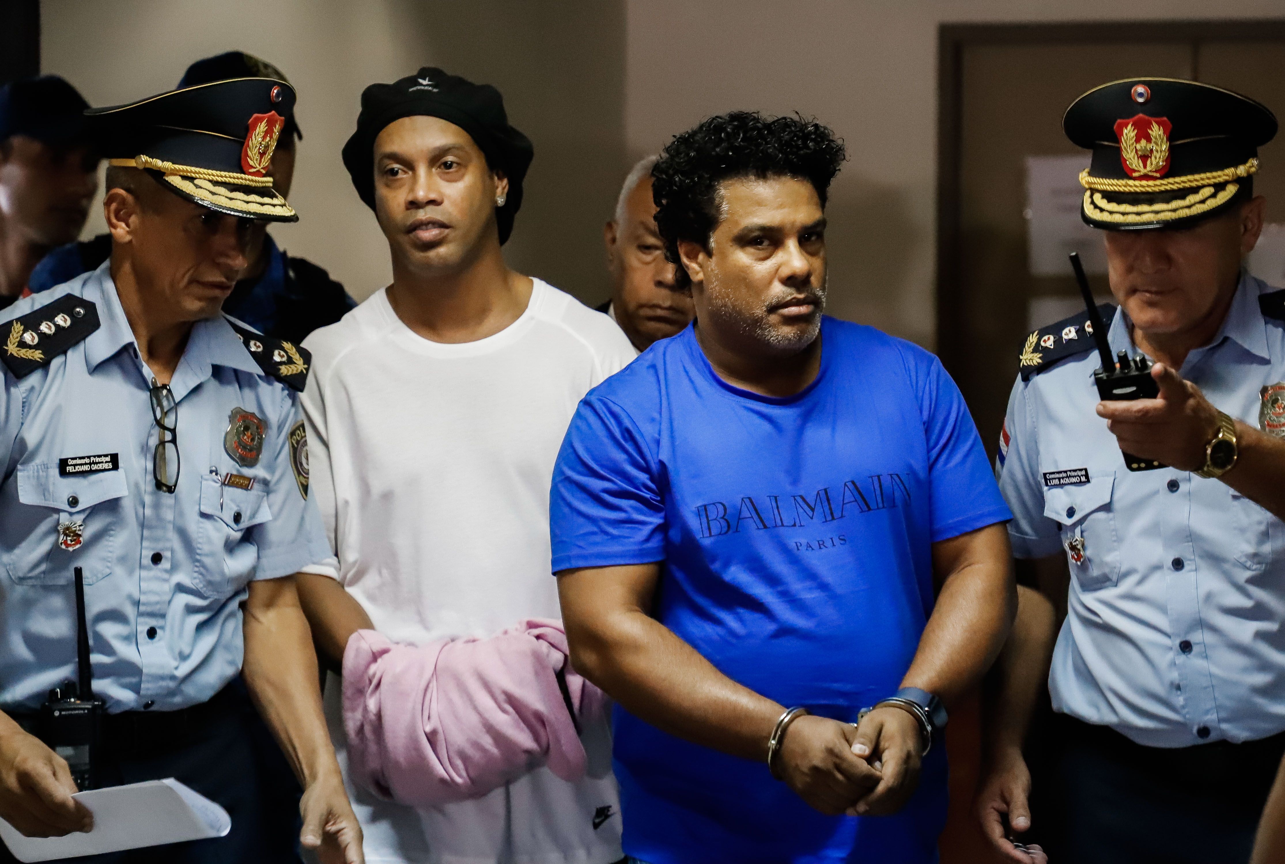 El brasileño Ronaldinho y su hermano Roberto, a su llegada este sábado al Palacio de Justicia, para una nueva audiencia de imposición de medidas. (Foto Prensa Libre: EFE).
