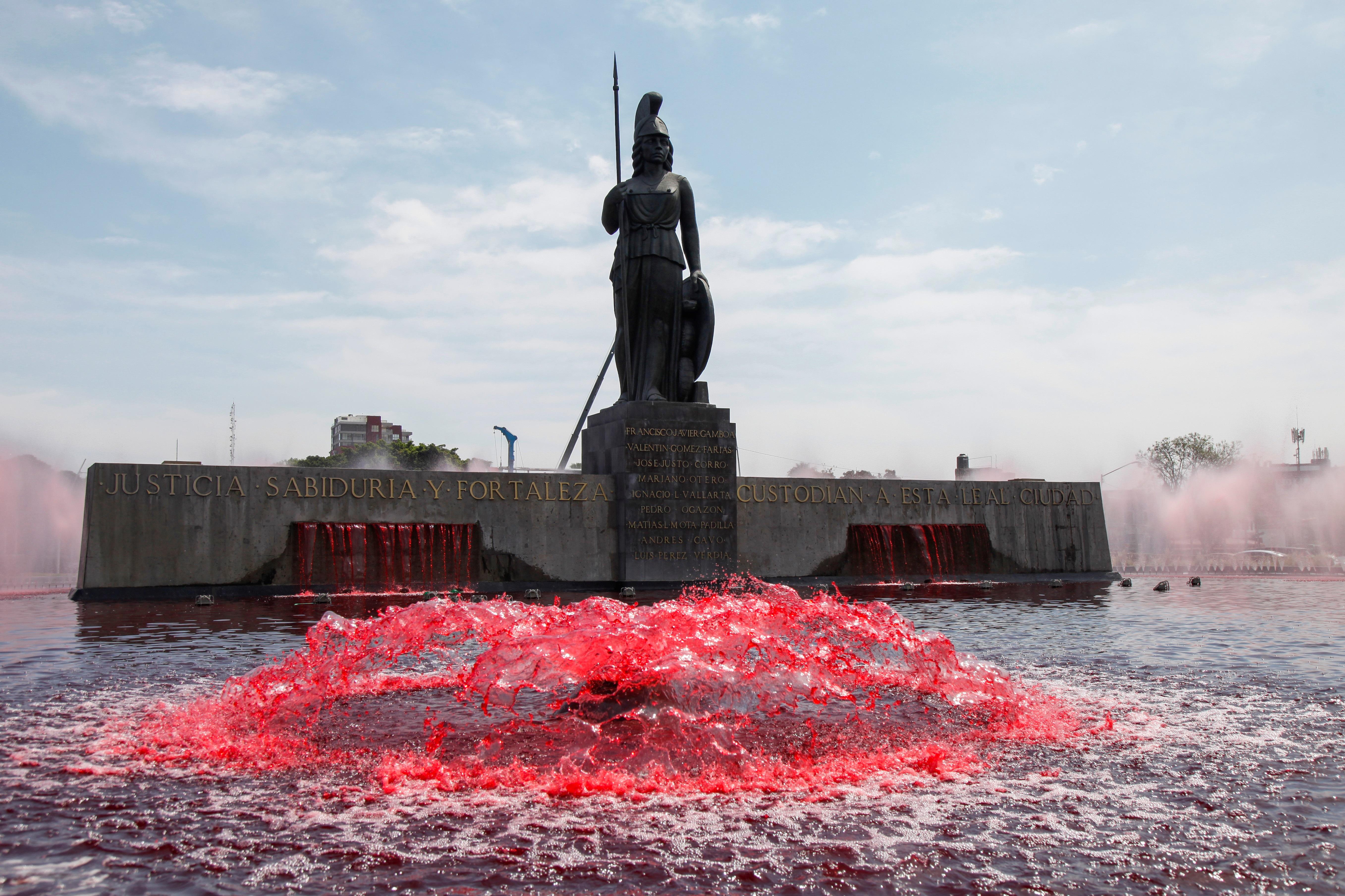 Vista general del monumento a la Minerva, en Guadalajara, México, el cual fue "teñido" de rojo por integrantes del colectivo Hilos para representar la sangre derramada por los feminicidios y a las mujeres. (Foto Prensa Libre: EFE)