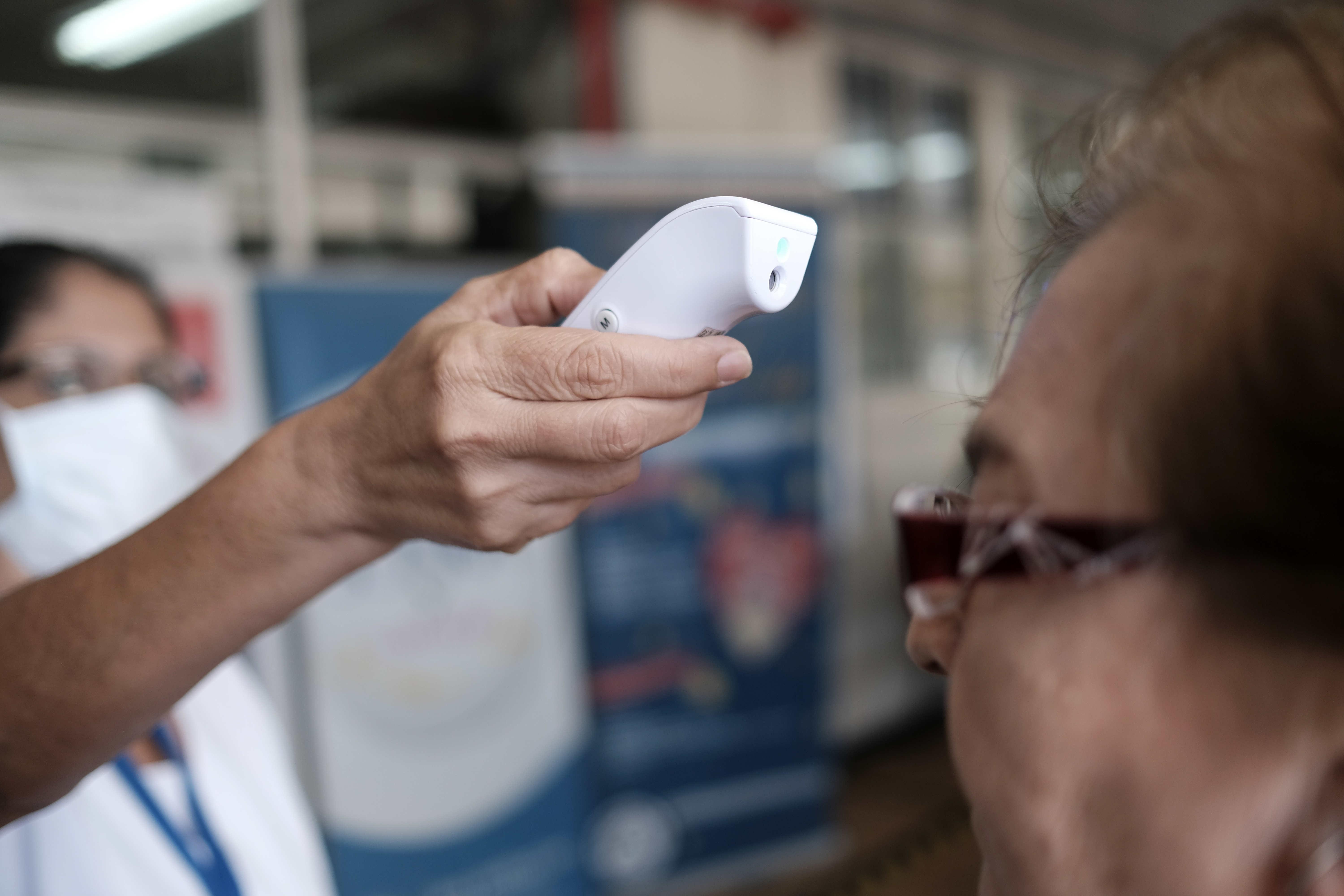 Una enfermera mide la temperatura de varias personas en el Hospital de la Mujer, en San José, Costa Rica. El Gobierno de Costa Rica informó del primer fallecido por coronavirus. (Foto Prensa Libre: EFE)