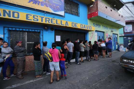 Vecinos de Mixco trataban de comprar artículos de primera necesidad en un depósito del sector. Foto Prensa Libre: Érick Ávila
