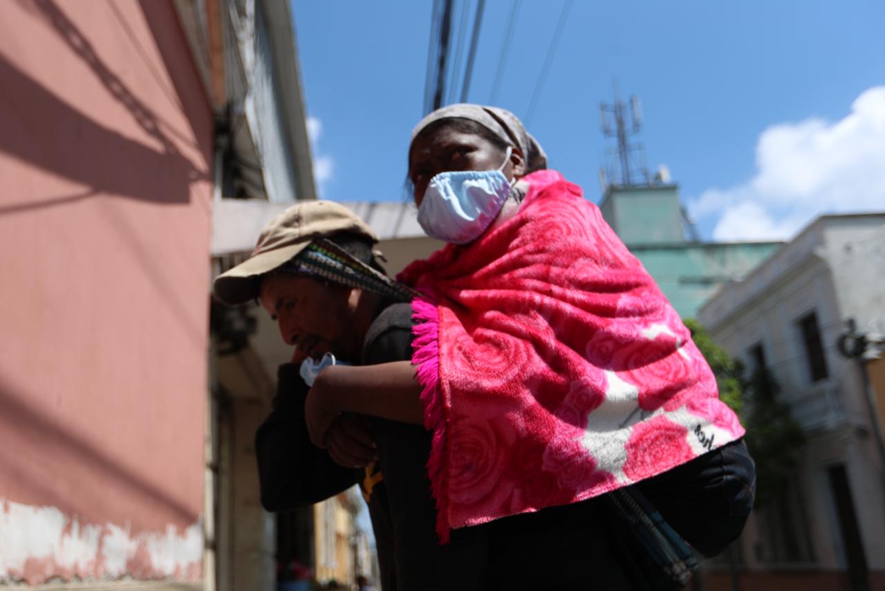 El 20 de marzo de 2020, Gilberto López carga a su esposa Sandra Garnillo, ambos originarios de Huehuetenango, del albergue donde se hospedan hacia Unaerc, en la zona 1 capitalina, para recibir hemodiálisis. (Foto Prensa Libre: Miriam Figueroa)