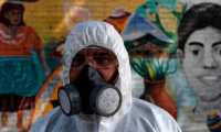 A municipal worker participates in a disinfection operation at eastern neighborhoods as a measure to prevent the spread of the new coronavirus, COVID-19, in San Salvador on March 18, 2020. - The president of El Salvador, Nayib Bukele, announced on Tuesday the closure of the country's main airport to passenger flights. Only the transit of cargo planes and humanitarian missions will be allowed, due to the coronavirus pandemic. (Photo by Yuri CORTEZ / AFP)