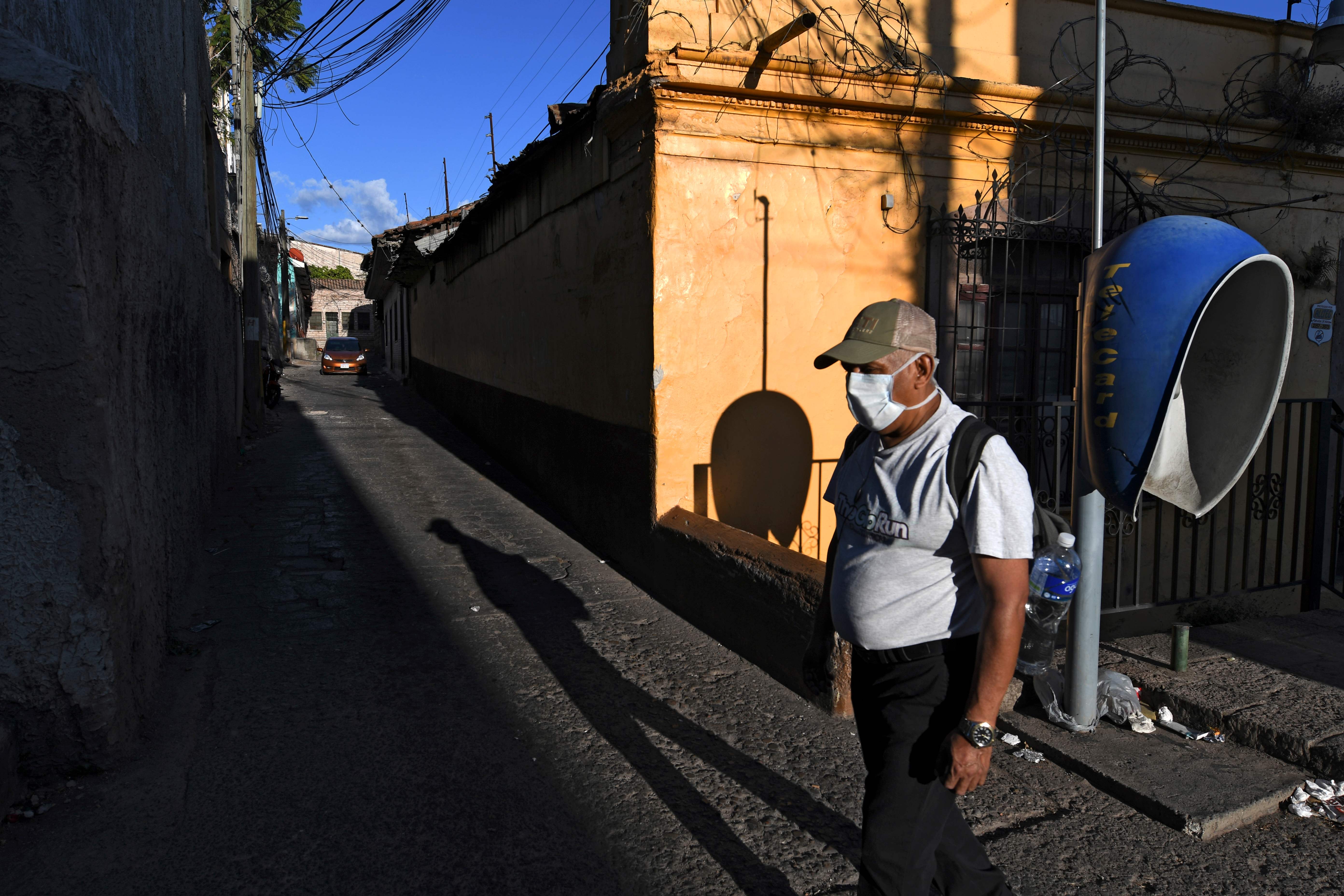 Un hombre usa una marscarilla para protegerse del coronavirus en una de las calles de Tegucigalpa. (Foto Prensa Libre: AFP)