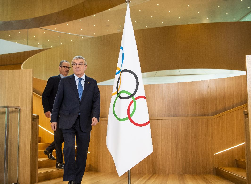 El presidente del COI, Thomas Bach -al frente- llega con Mark Adams, portavoz del Comité Olímpico Internacional, para una declaración sobre el coronavirus y los Juegos Olímpicos de Tokio 2020. (Foto Prensa Libre: EFE) 