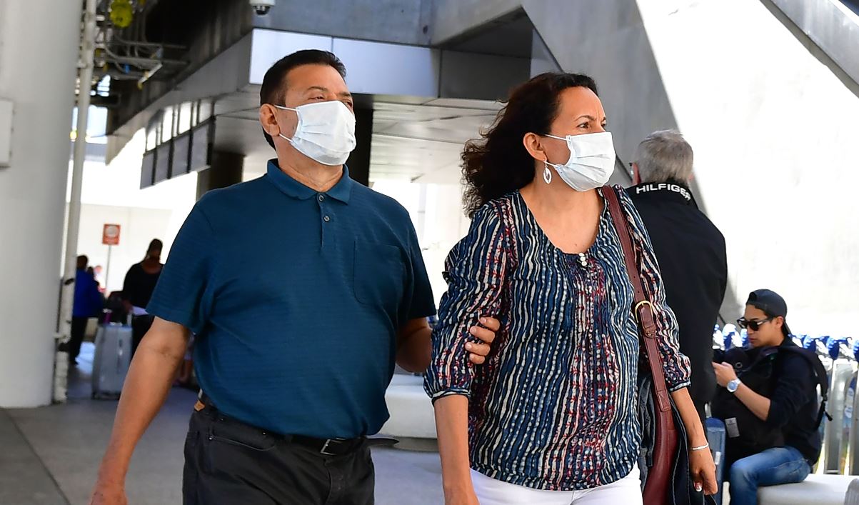 La gente usa máscaras faciales en el Aeropuerto Internacional de Los Ángeles, California, ya que se ha registrado muertes en Estados Unidos por el virus. (Foto Prensa Libre: AFP).  