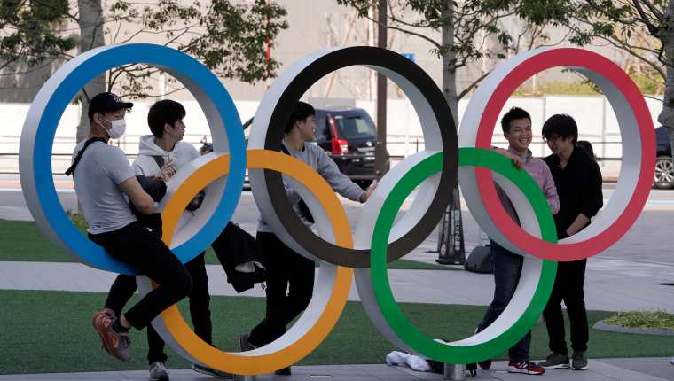 Visitantes se toman fotos en los Anillos Olímpicos que se muestran en el Comité Olímpico de Japón, en Tokio. (Foto Prensa Libre: EFE)