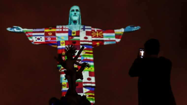  Las banderas de los países afectados por el coronavirus son proyectadas en la estatua de Cristo Redentor este miércoles, durante un acto de apoyo para los aproximadamente 150 países con casos de coronavirus, en Río de Janeiro, Brasil. (Foto Prensa Libre: EFE)