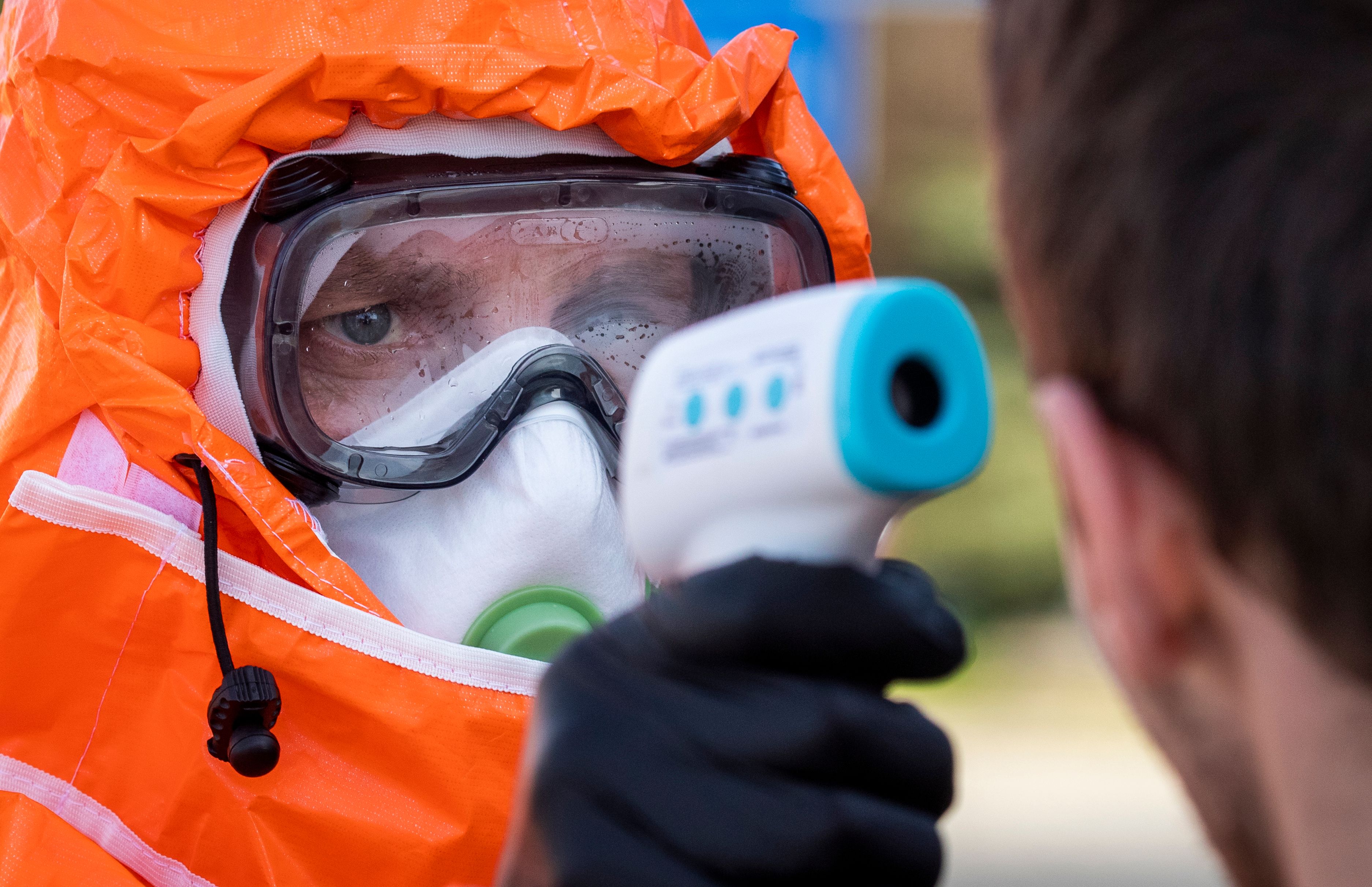 A Polish health official checks the temperature of returning Poles crossing the Polish-German border from the eastern German town of Frankfurt (Oder) to Slubice on March 16, 2020, as measures are taken to slow down the spread of the novel coronavirus. - Polish Prime Minister Mateusz Morawiecki said Poland's borders would be closed to foreigners for 10 days, but that the government might prolong the shutdown. Two weeks of quarantine will also be imposed on people returning from abroad. (Photo by Odd ANDERSEN / AFP)