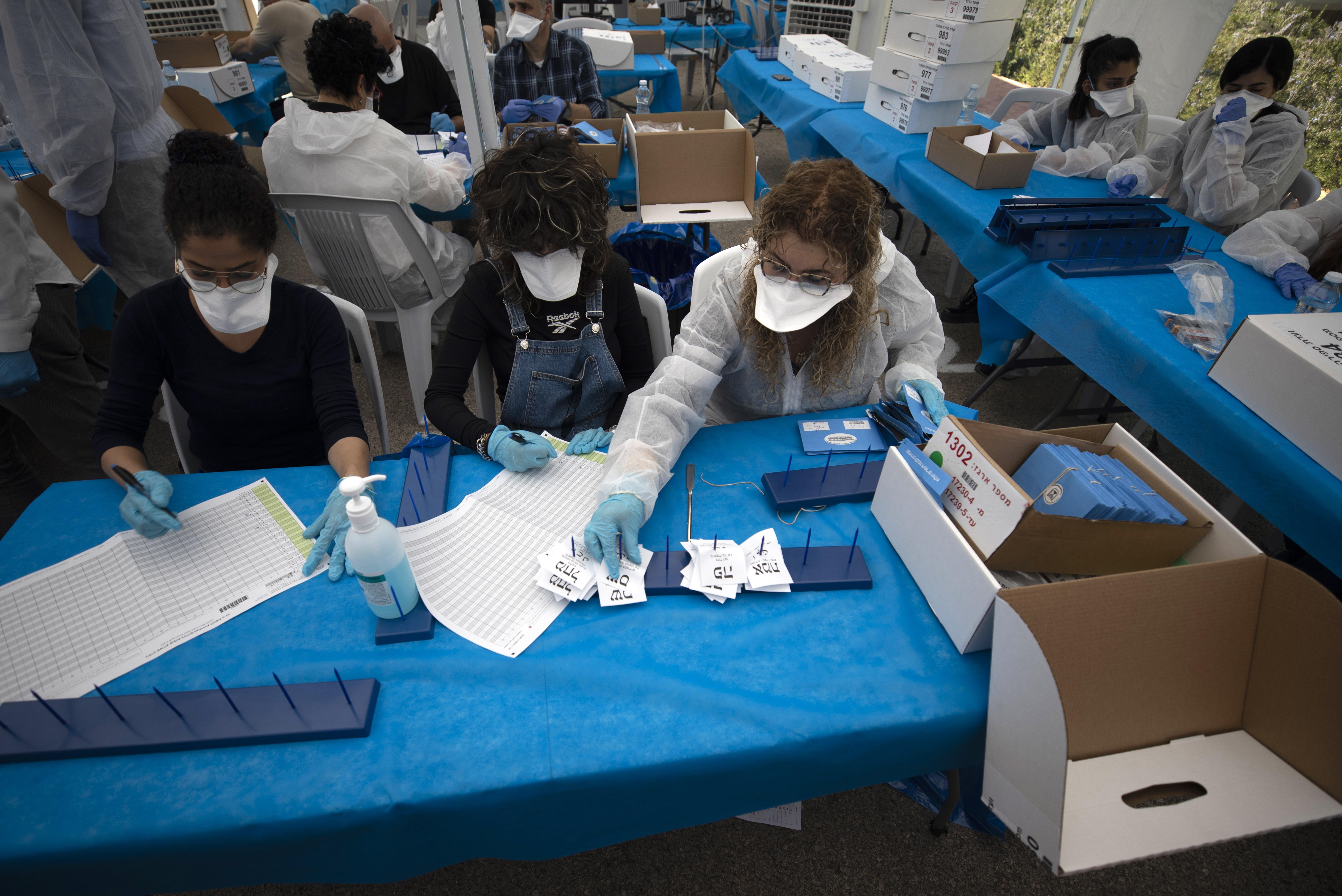 Shoham (Israel), 04/03/2020.- Israeli employees of the Central Elections Committee (ECE) wearing protective suit and masks count ballots casted by Israelis in home quarantine on coronavirus suspicion from all over Israel, in Shoham town, Israel, 04 March 2020. Israelis on 02 March voted to elect the 120 members of the 23rd Knesset, or parliament. (Elecciones) EFE/EPA/ATEF SAFADI