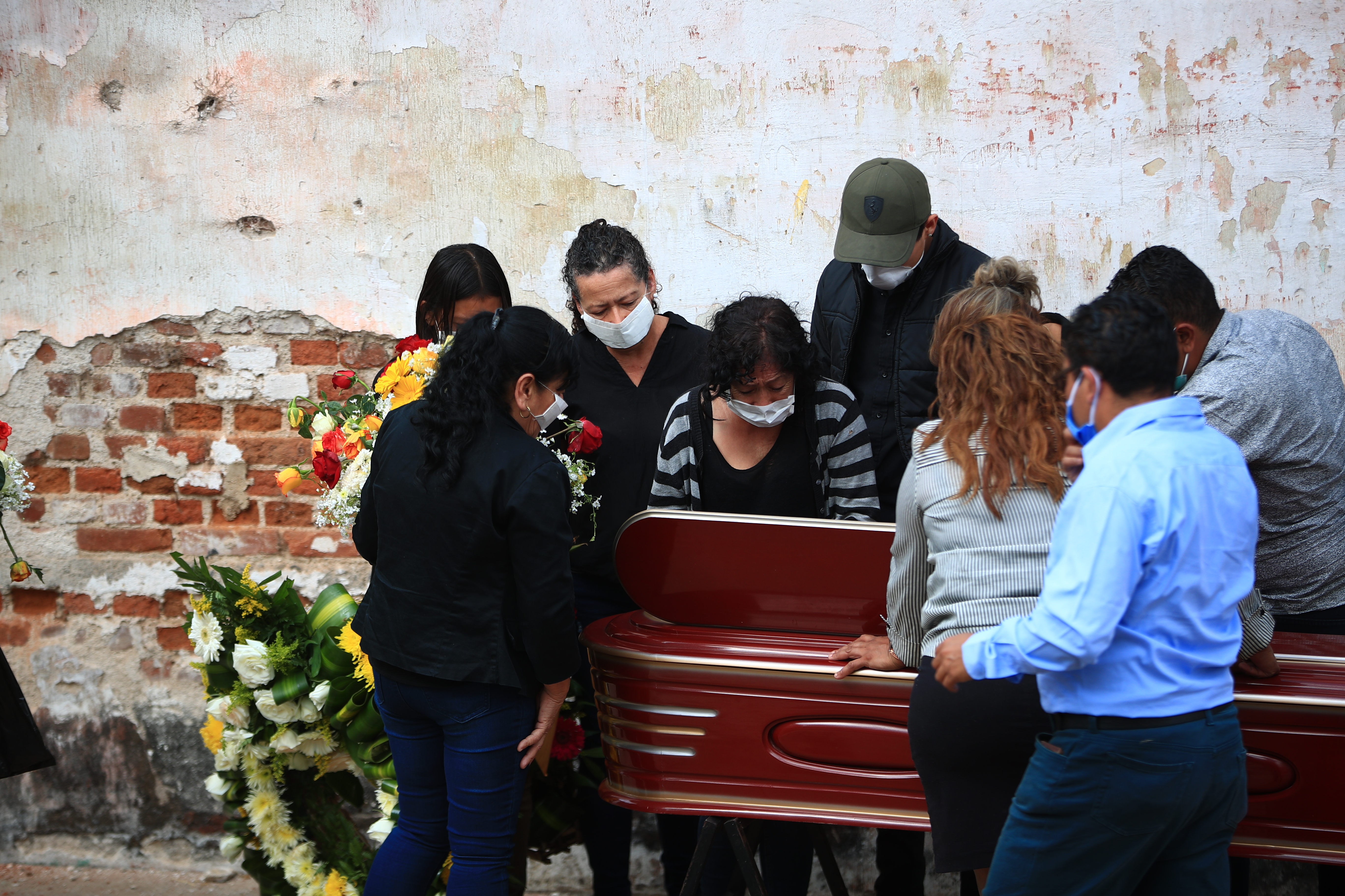 Previo a la sepultura familiares de un muerto abren la ventanilla y ven por última ocasión de su ser querido en el cementerio La Verbena, en zona 7. (Foto Prensa Libre: Carlos Hernández) 
