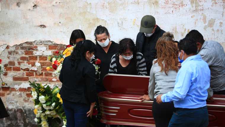 Previo a la sepultura familiares de un muerto abren la ventanilla y ven por última ocasión de su ser querido en el cementerio La Verbena, en zona 7. (Foto Prensa Libre: Carlos Hernández) 
