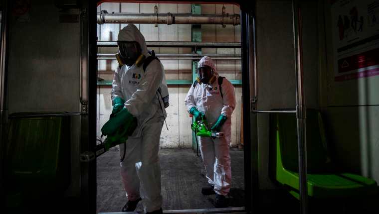 Trabajadores desinfectan el metro de Ciudad de México. (Foto Prensa Libre: AFP)