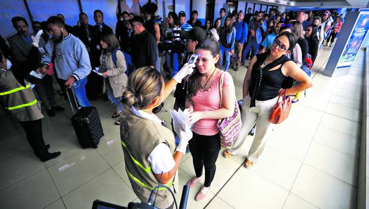 Pasajeros pasan el control sanitario en el Aeropuerto Internacional La Aurora. (Foto Prensa Libre: Hemeroteca).