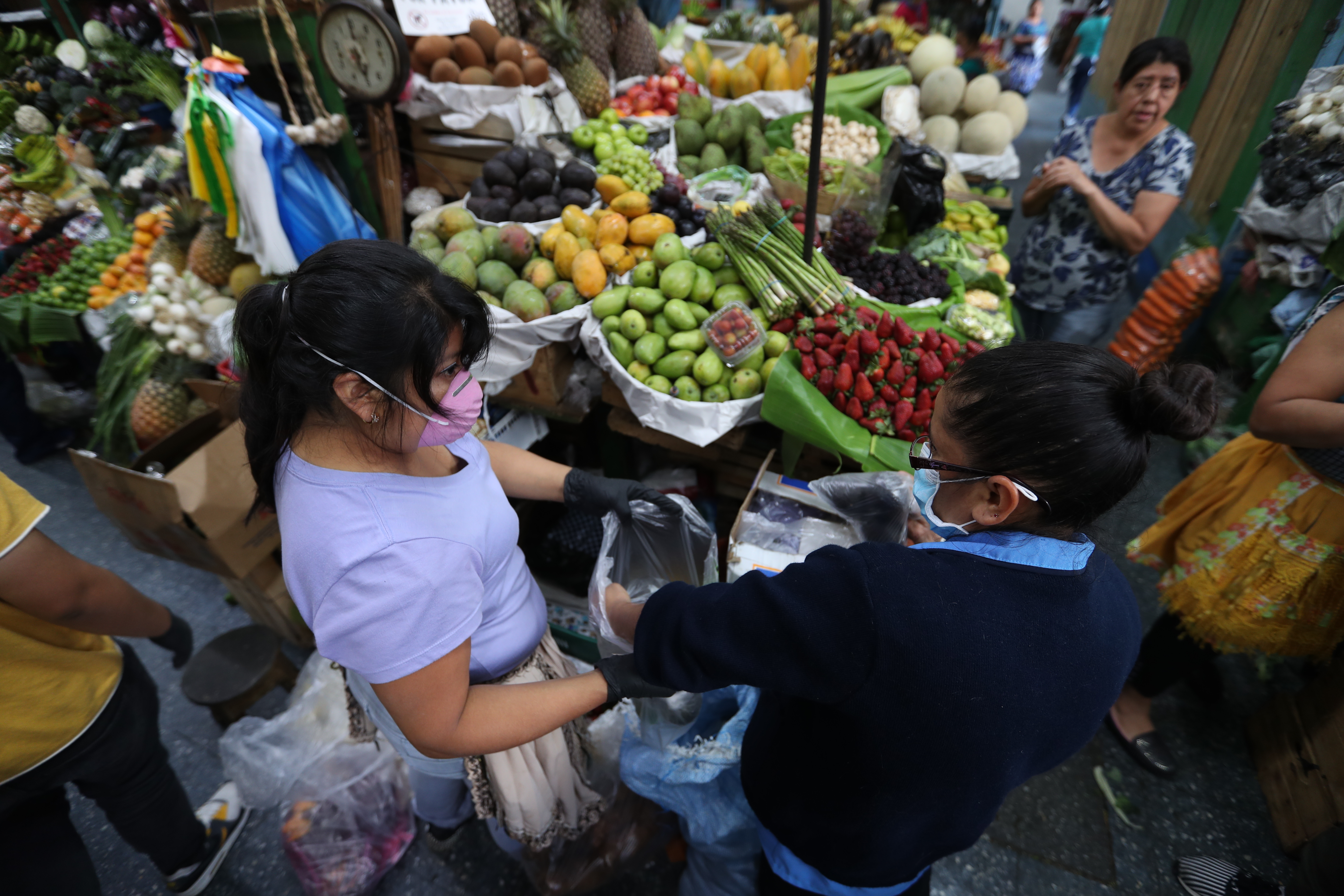Vendedores del Mercado Central en la Ciudad de Guatemala se cubrieron boca y nariz para poder atender a los clientes que buscaban sus productos.