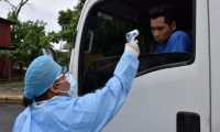 Una enfermera del área de salud de Izabal toma muestra de temperatura a un piloto procedente de El Salvador, en el puesto fronterizo entre Guatemala y Honduras. (Foto Prensa Libre: Dony Stewart)