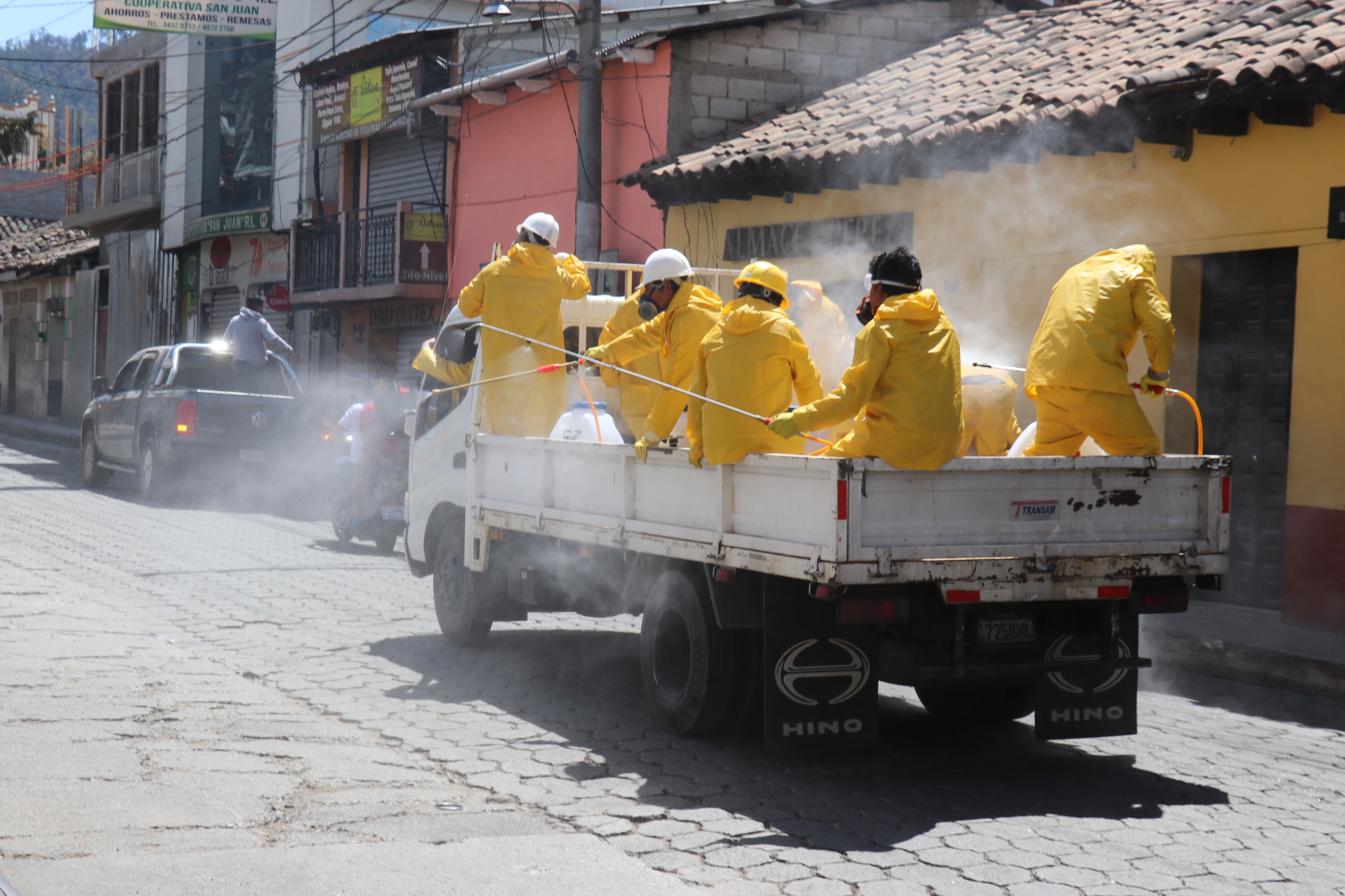 Empleados de una empresa de limpieza fumigan una de  las calles de Chichicastenango, Quiché, para prevenir contagio de coronavirus.  (Foto Prensa Libre: Héctor Cordero)