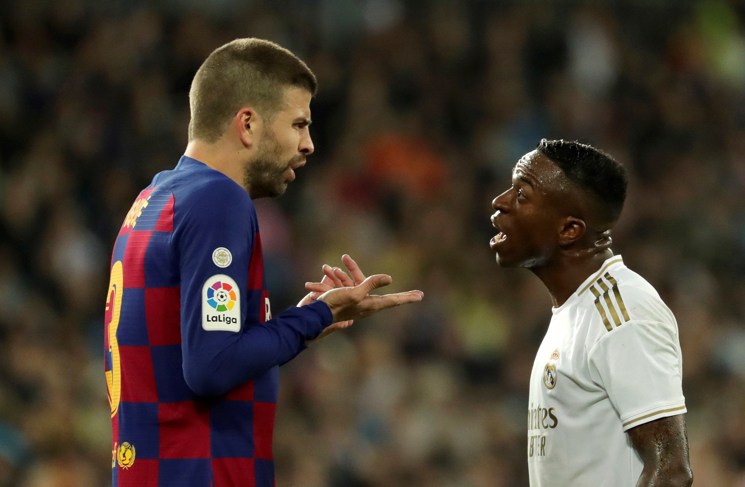 El defensor Gerard Piqué (i) del Barcelona y el delantero brasileño Vinicius del Real Madrid, discuten durante el clásico español. (Foto Prensa Libre: EFE)