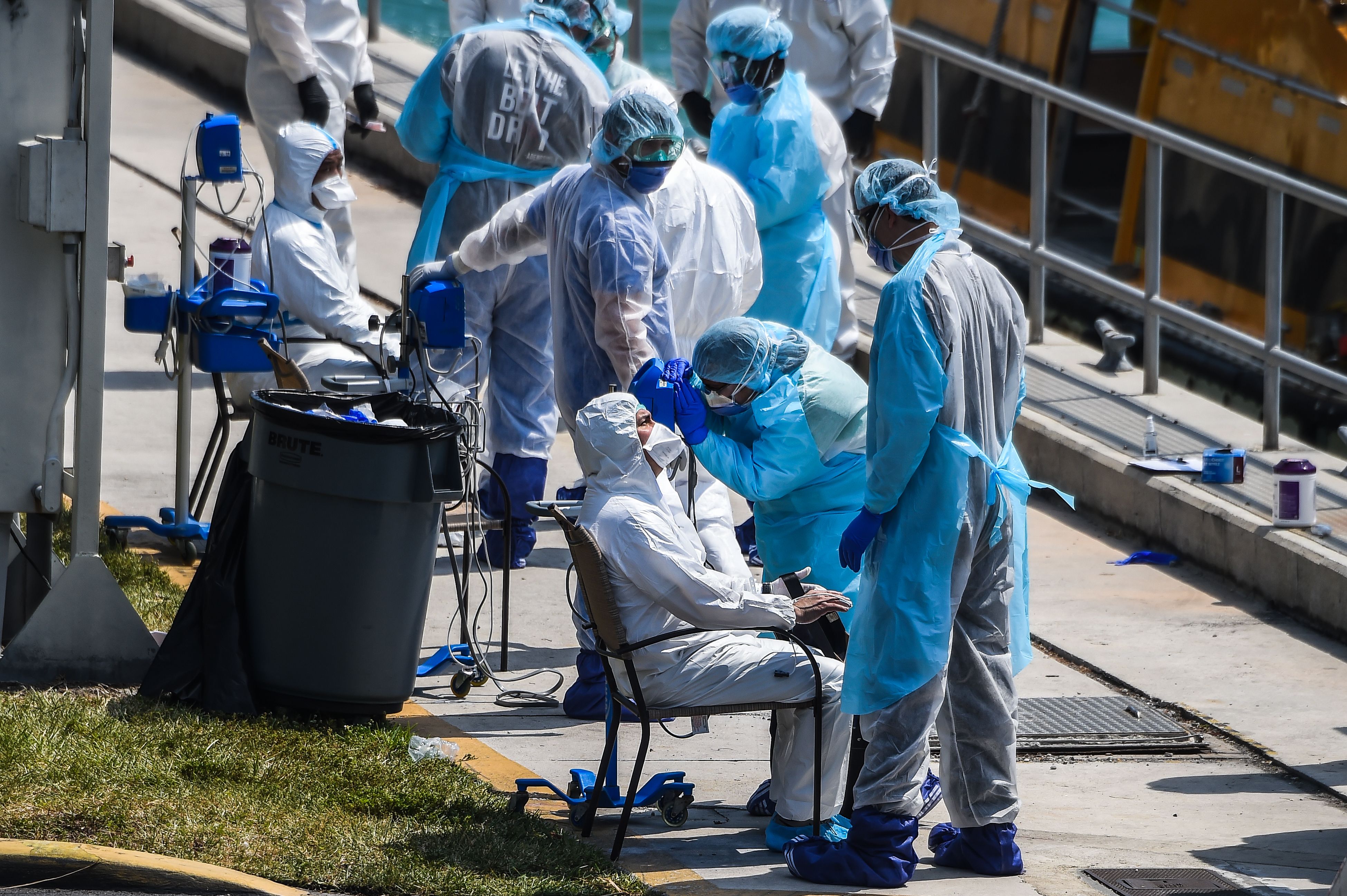 TOPSHOT - Medics assist sick crew members of the two boats as they arrive at the U.S. Coast Guard Base in Miami, on March 26, 2020. - The U.S. Coast Guard is facilitating medical evacuations Thursday after requests were made by Costa Magica and Costa Favolosa for life-critical care ashore for multiple crew members presenting with respiratory symptoms consistent with pneumonia and bronchitis. (Photo by CHANDAN KHANNA / AFP)