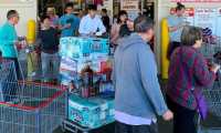 Shoppers buy toilet paper, food and water at a store, as people begin to panic buy and stockpile essentials from fear that supplies will be affected by the spread of the COVID-19, coronavirus outbreak across the country, in Los Angeles, California on February 29, 2020. - The US has suffered its first virus related death as the number of novel coronavirus cases in the world rose to 85,919, including 2,941 deaths, across 61 countries and territories. (Photo by Mark RALSTON / AFP)