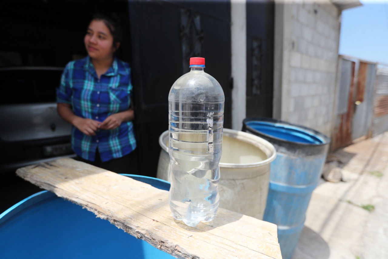 Paola Flores, vecina de El Carmen, Santa Catarina Pinula, muestra que su agua la guarda incluso en botellas de gaseosas para conservarla por algunos días, mientras logran abastecerse de nuevo. Foto Prensa Libre: Érick Ávila.