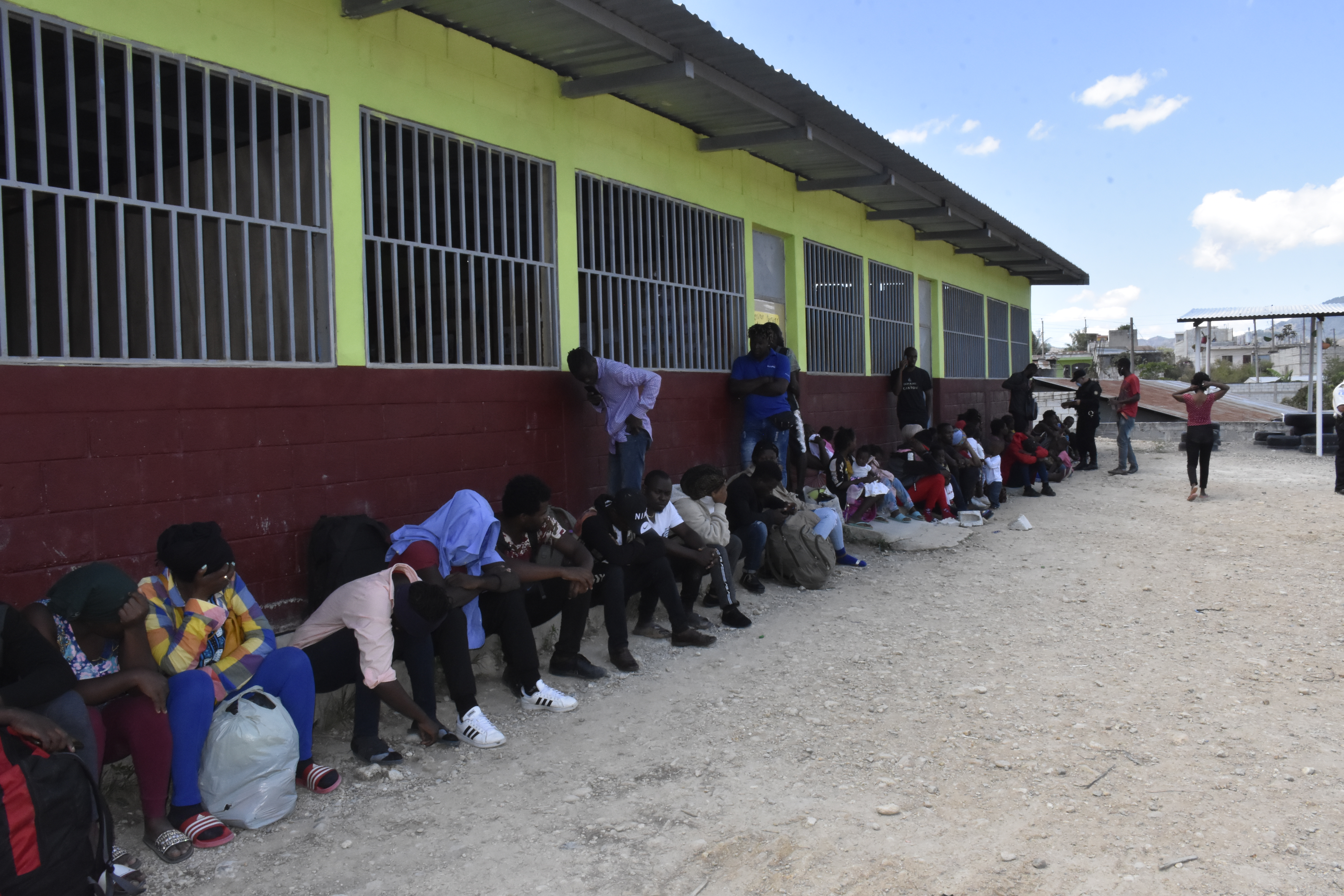 Un grupo de inmigrantes haitianos fue albergado en un instituto de educación básica de Esquipulas y son custodiados por agentes de la Policía Nacional Civil y soldados del Ejército Nacional. (Foto Prensa Libre: Cortesía) 