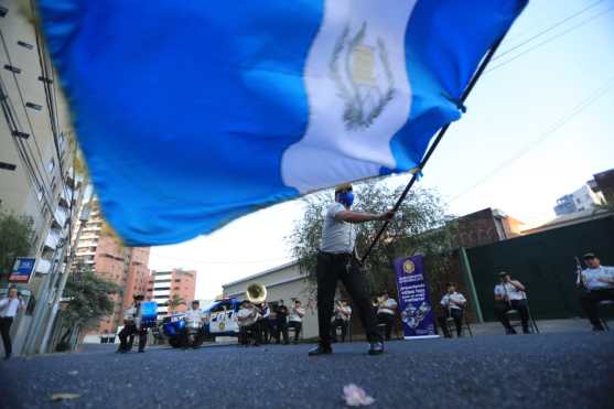 Mientras tocaban, los antes también ondeaban una bandera de Guatemala y esto animaba a las personas que veían desde sus departamentos. Foto Prensa Libre: Juan Diego González