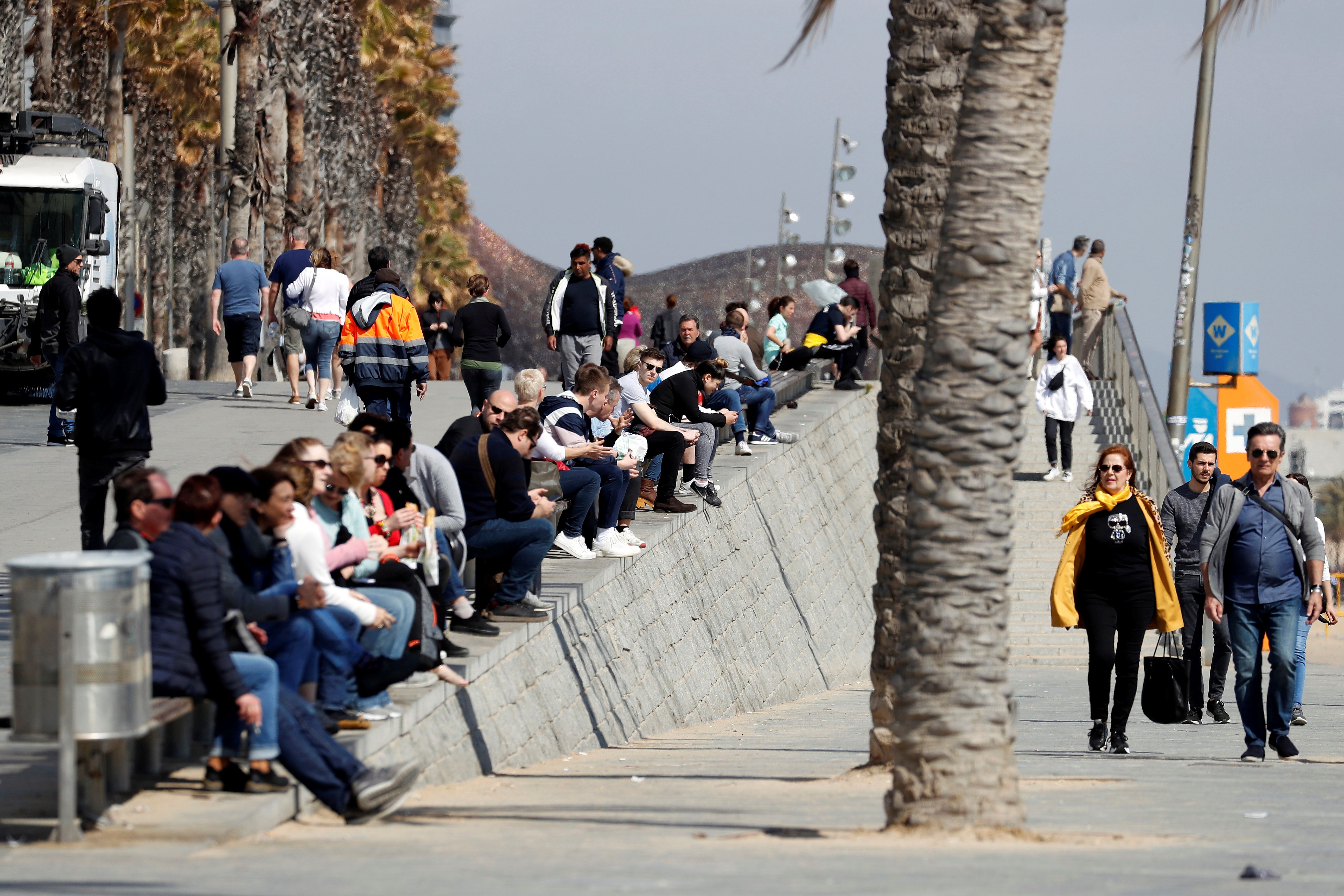 Varias personas toman el sol cerca de la playa de Barcelona a pesar las medidas que se han adoptado en otras ciudades por el covid-19. (Foto Prensa Libre: EFE)