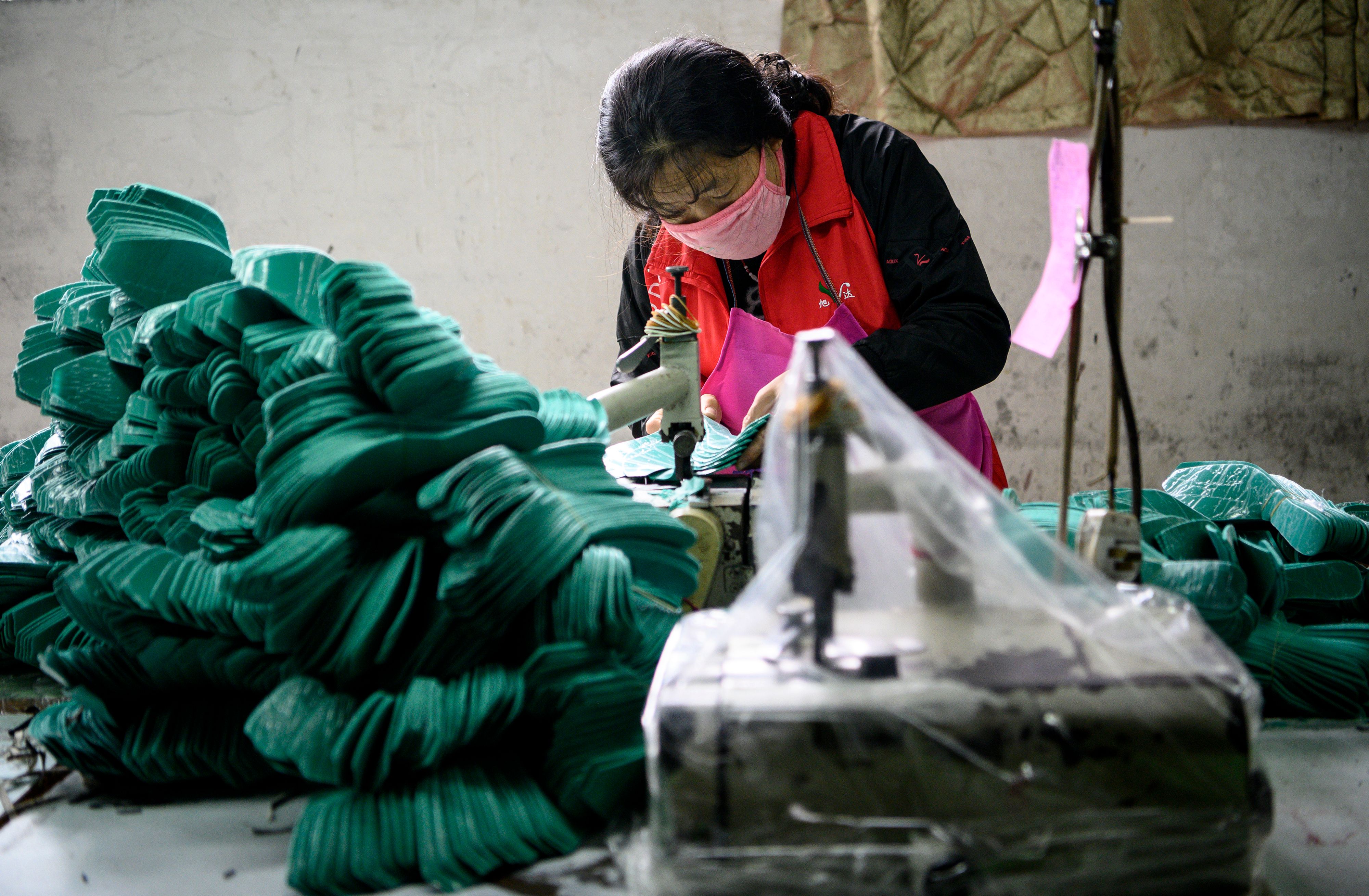 Trabajadores de  la fábrica Xuda producen con la poca materia prima que tienen debido a la falta de suministros. (Foto Prensa Libre: AFP)