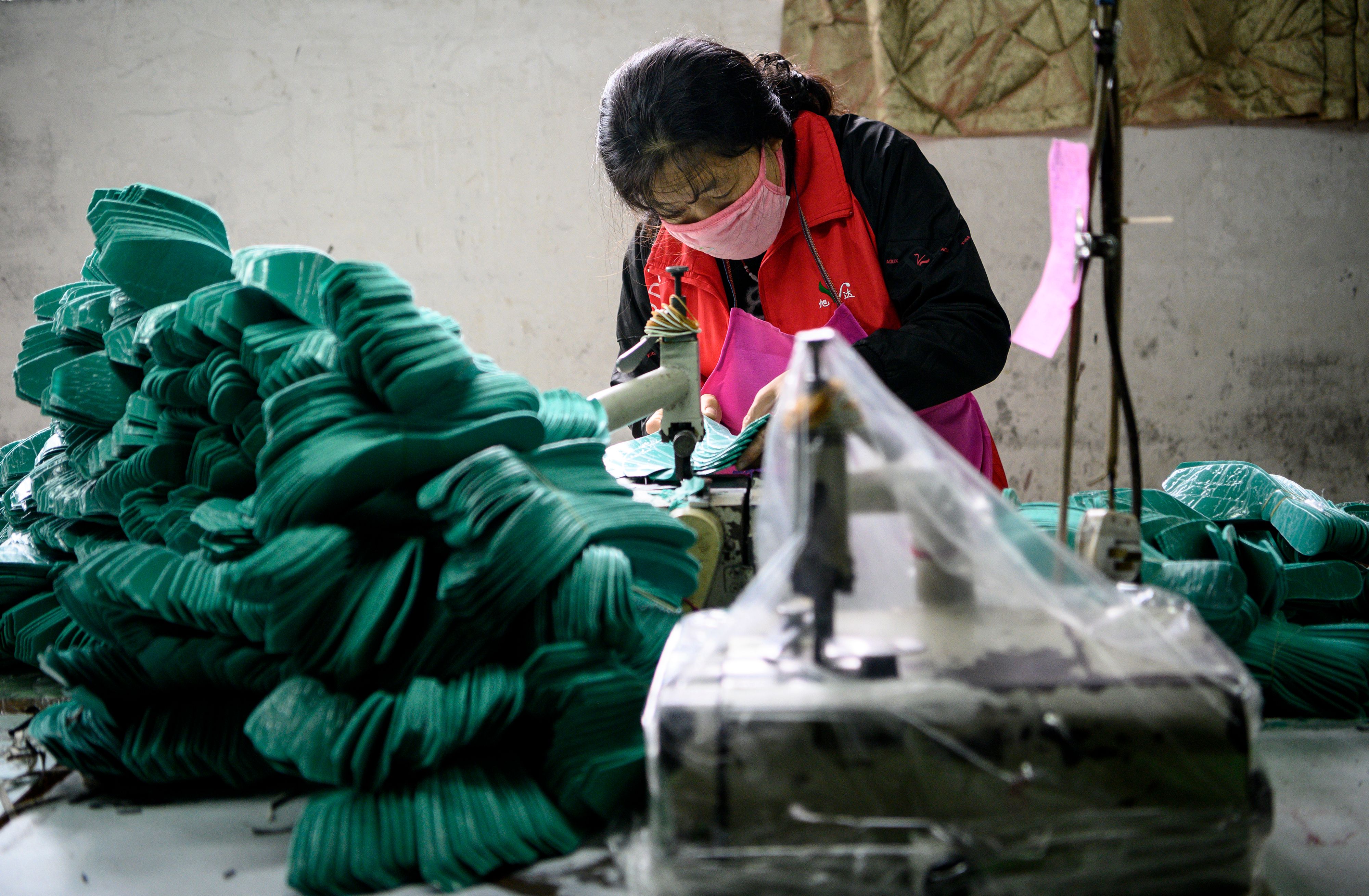 Trabajadores de  la fábrica Xuda producen con la poca materia prima que tienen debido a la falta de suministros. (Foto AFP)