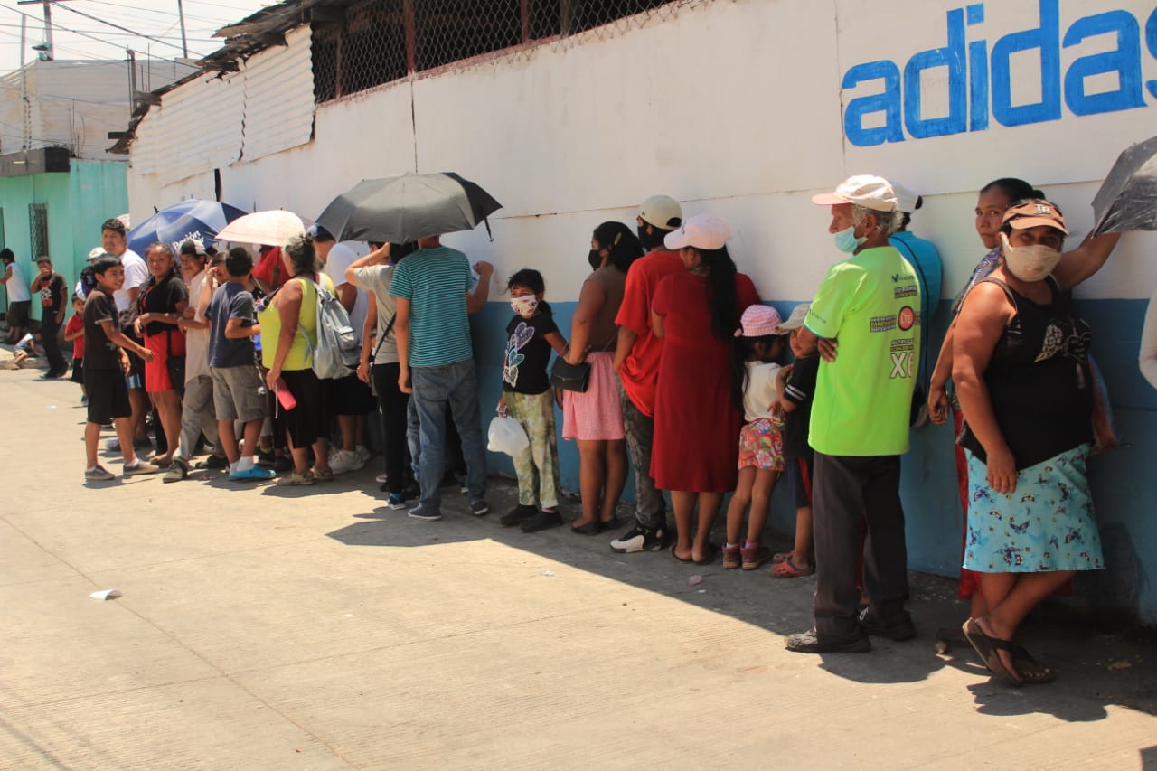 Personas hacen fila en el comedor social de la zona 6 de Mixco para recibir su almuerzo. (Foto Prensa Libre: Byron García)