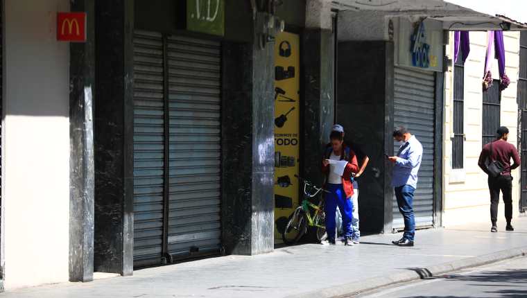 Personas esperan en fila para ingresar a una casa de empeño, en zona 1, y gestionar préstamos cediendo artículos. (Foto Prensa Libre: Carlos Hernández) 