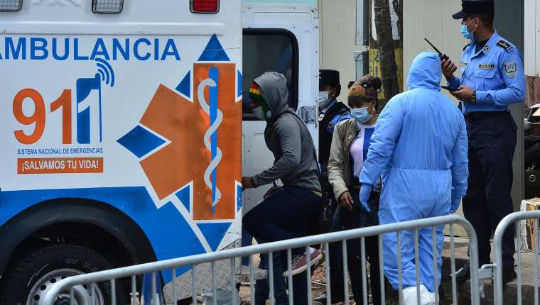 Los hondureños que ingresan al país son escoltados por las autoridades en una ambulancia para ser puestos en cuarentena y  evitar la propagación del nuevo coronavirus en Tegucigalpa. (Foto Prensa Libre: AFP)