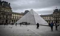 (FILES) In this file photo taken on February 28, 2020 people visit the Louvre Pyramide in Paris. - An informational meeting on the public health situation linked to Covid-19 (novel Coronavirus) prevention measures has delayed the opening of the Louvre Museum on March 1, 2020. (Photo by STEPHANE DE SAKUTIN / AFP)
