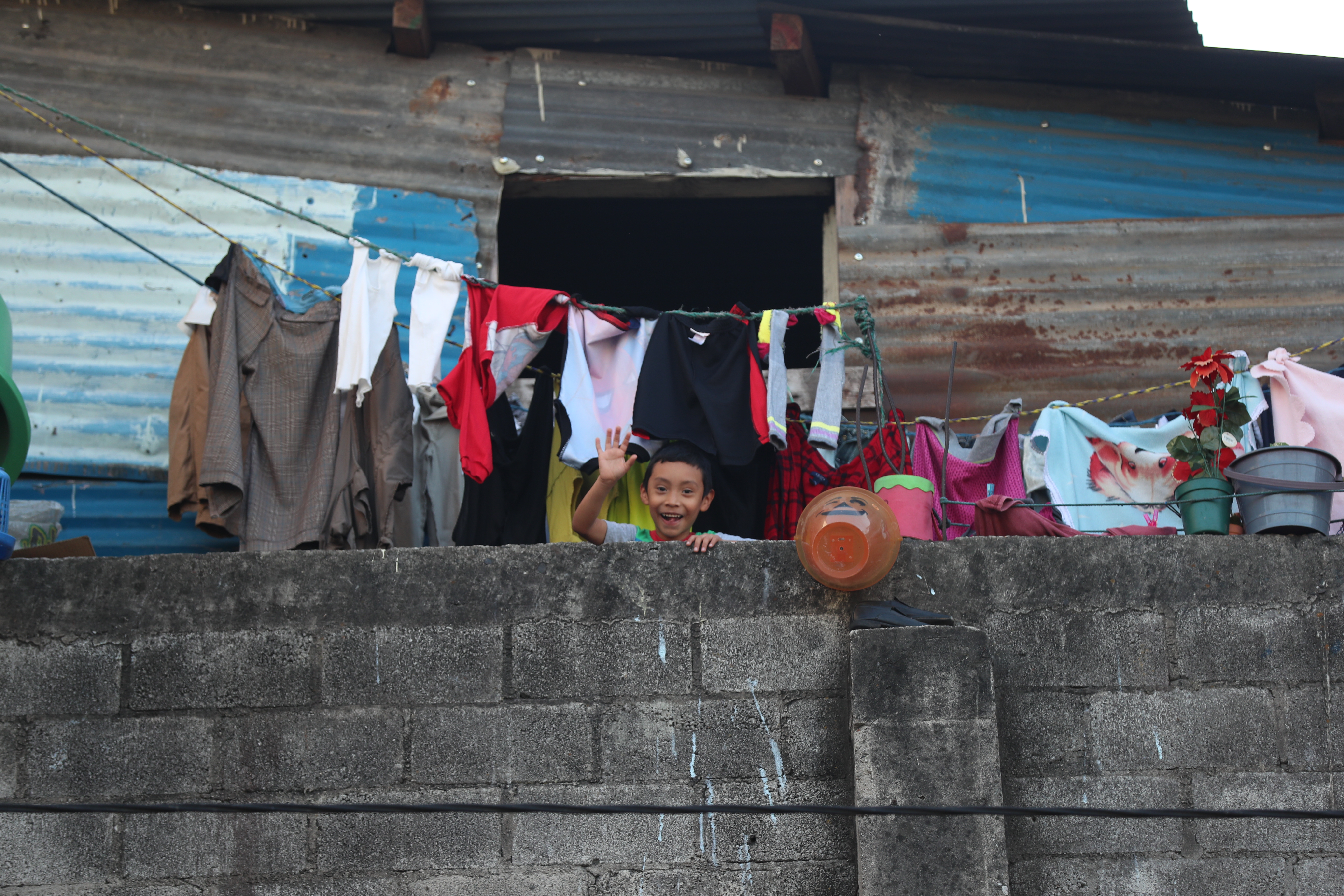 Un niño saluda  al lente, desde su vivienda ubicada en colonia El Incienso, zona 3. Fotografía Prensa Libre: Miriam Figueroa. 