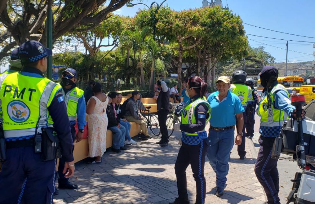 Oficiales de Tránsito de Villa Nueva tratan de persuadir a personas que descansan en el parque central de la localidad a que regresen a sus casas. (Foto: Cortesía)