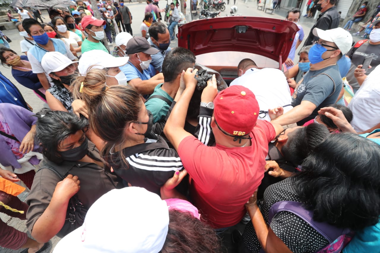 Personas se aglomeran para recibir un pan para el desayuno en una asentamiento de la zona 7, este 25 de abril de 2020. (Foto Prensa Libre: Érick Ávila).