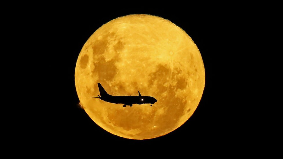 Un avión pasa por delante de la Luna, desde Curitiba, Brasil, el 9 de marzo de 2020. GETTY IMAGES