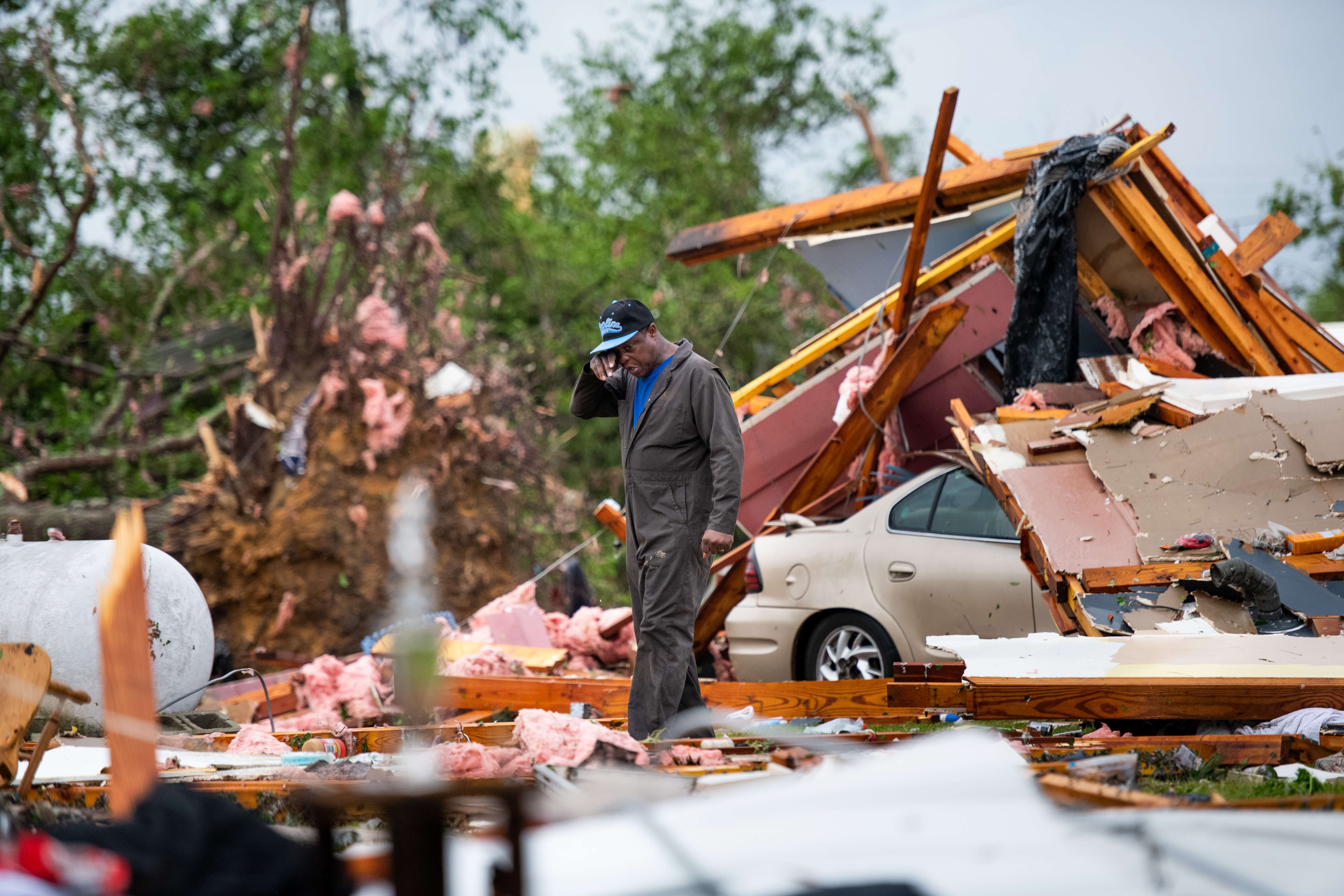 Un hombre busca sus pertenencias entre los restos que dejaron los tornados. (Foto Prensa Libre: AFP)