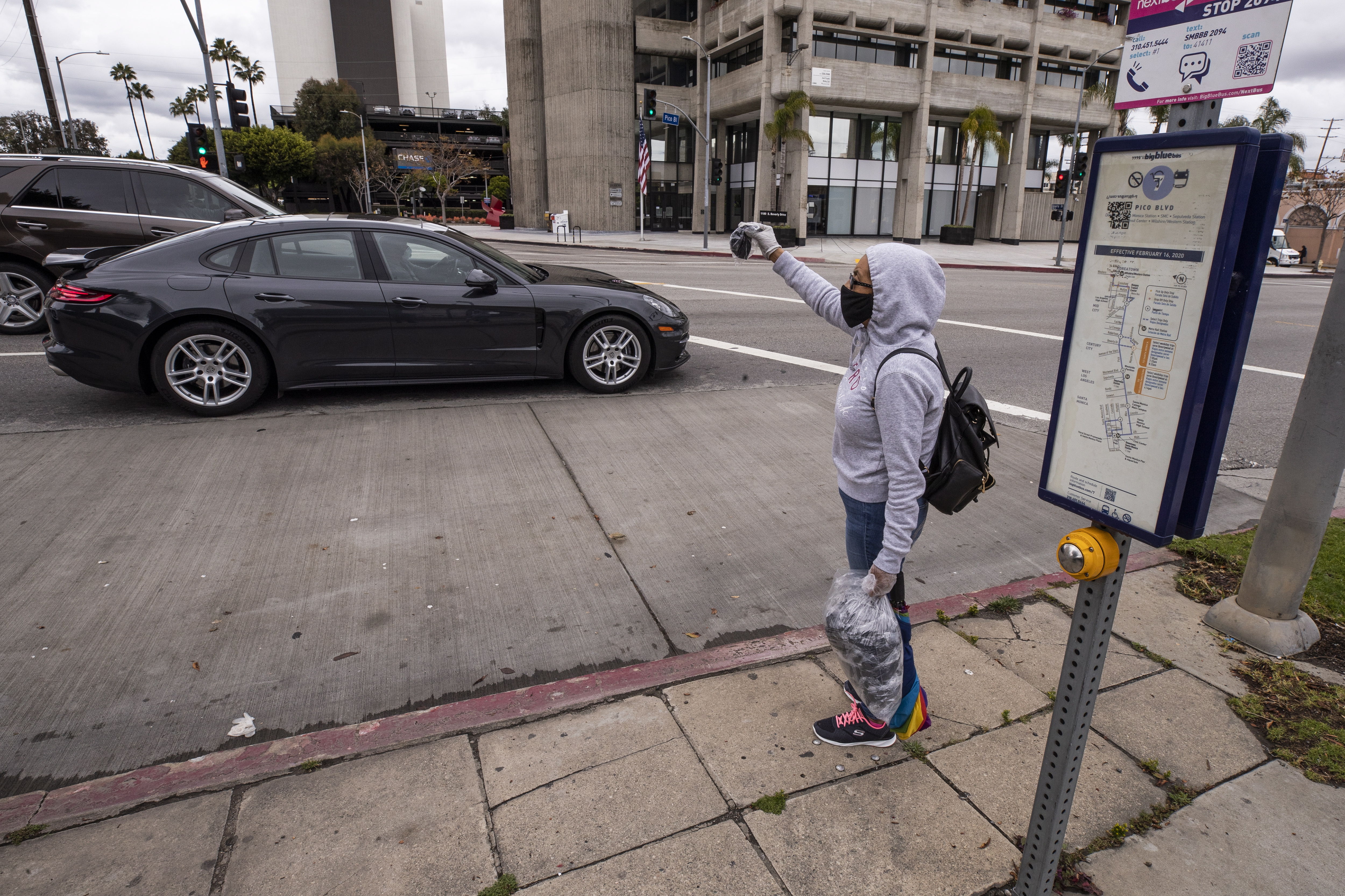 María vende máscaras faciales en la esquina de una calle después de perder su trabajo en medio de la pandemia de coronavirus en Los Ángeles, California, EE. UU. (Foto Prensa Libre: EFE)