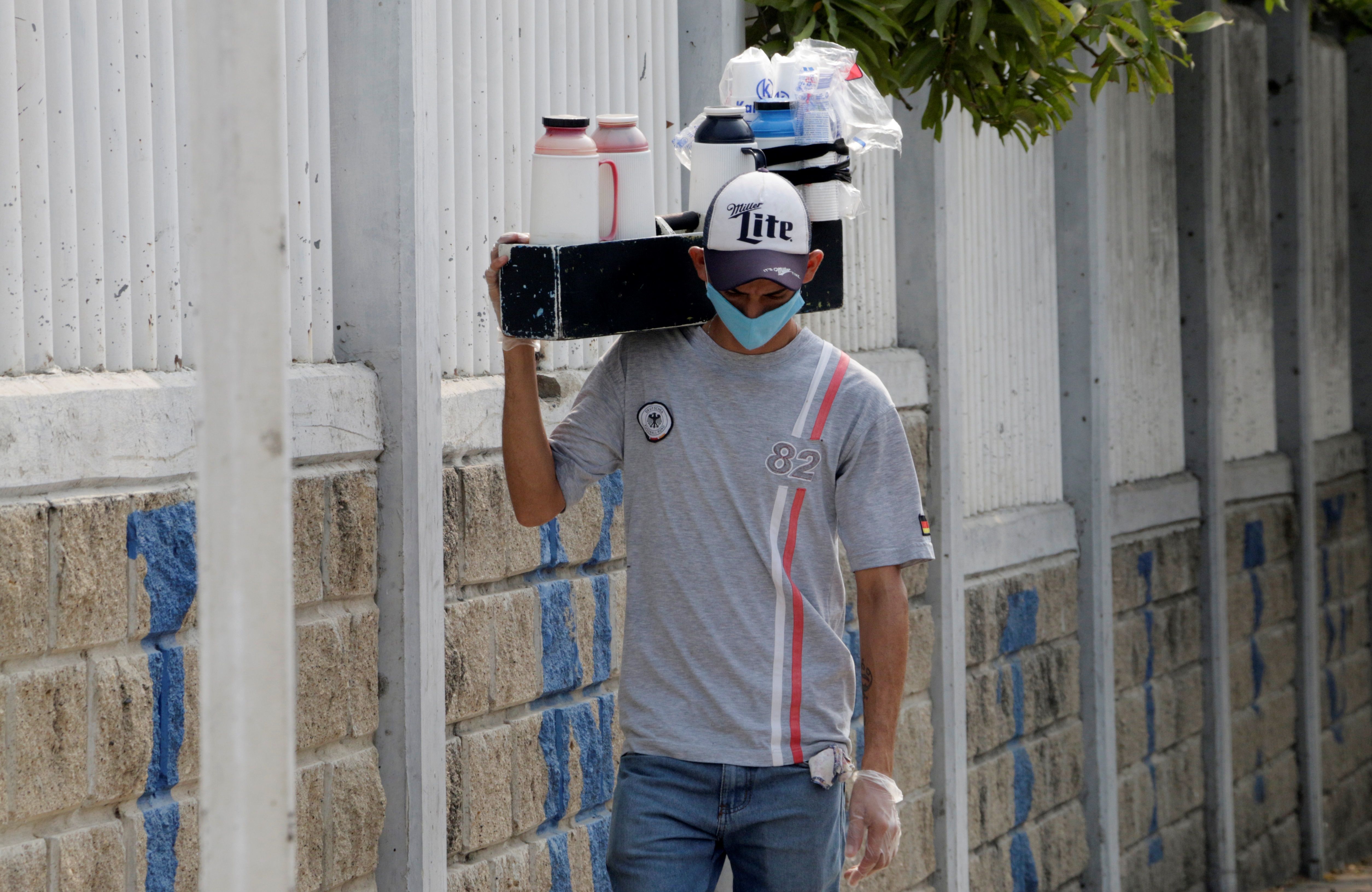AME832. CARTAGENA (COLOMBIA), 07/04/2020.- Un hombre vende café en la calle pese a las restricciones impuestas para prevenir el contagio de Covid-19 este martes en Cartagena (Colombia). En Colombia se cuentan por miles las personas que en todas las ciudades les toca salir todos los días a las calles para buscar con sus trabajos informales ganarse unos pesos para llevar alimentos a sus familias. EFE/Ricardo Maldonado Rozo