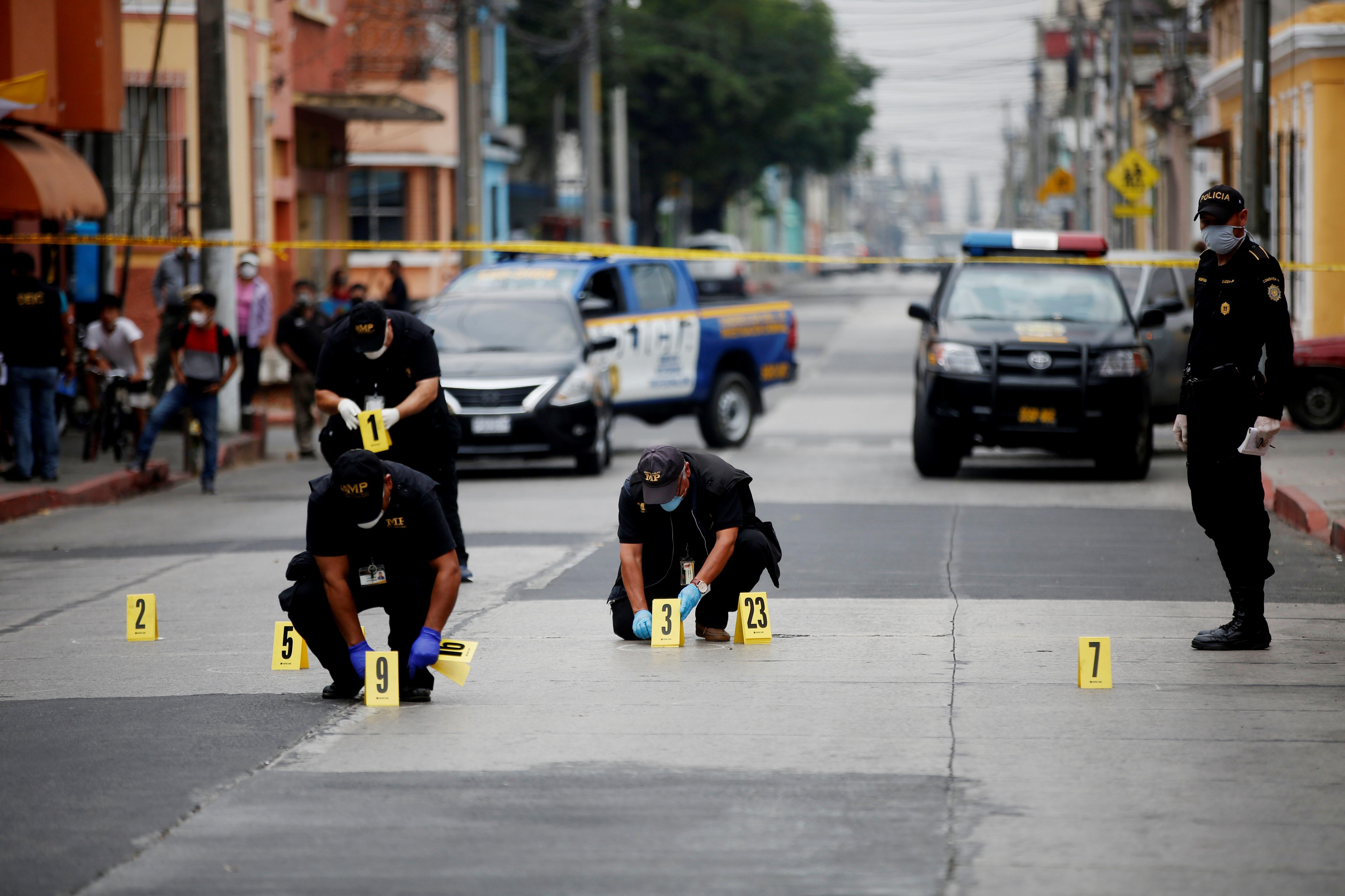 Técnicos, fiscales del Ministerio Público y policías trabajan en la escena del crimen, donde un hombre murió en un ataque armado en la zona 1. Fotografía Prensa Libre: EFE. 
