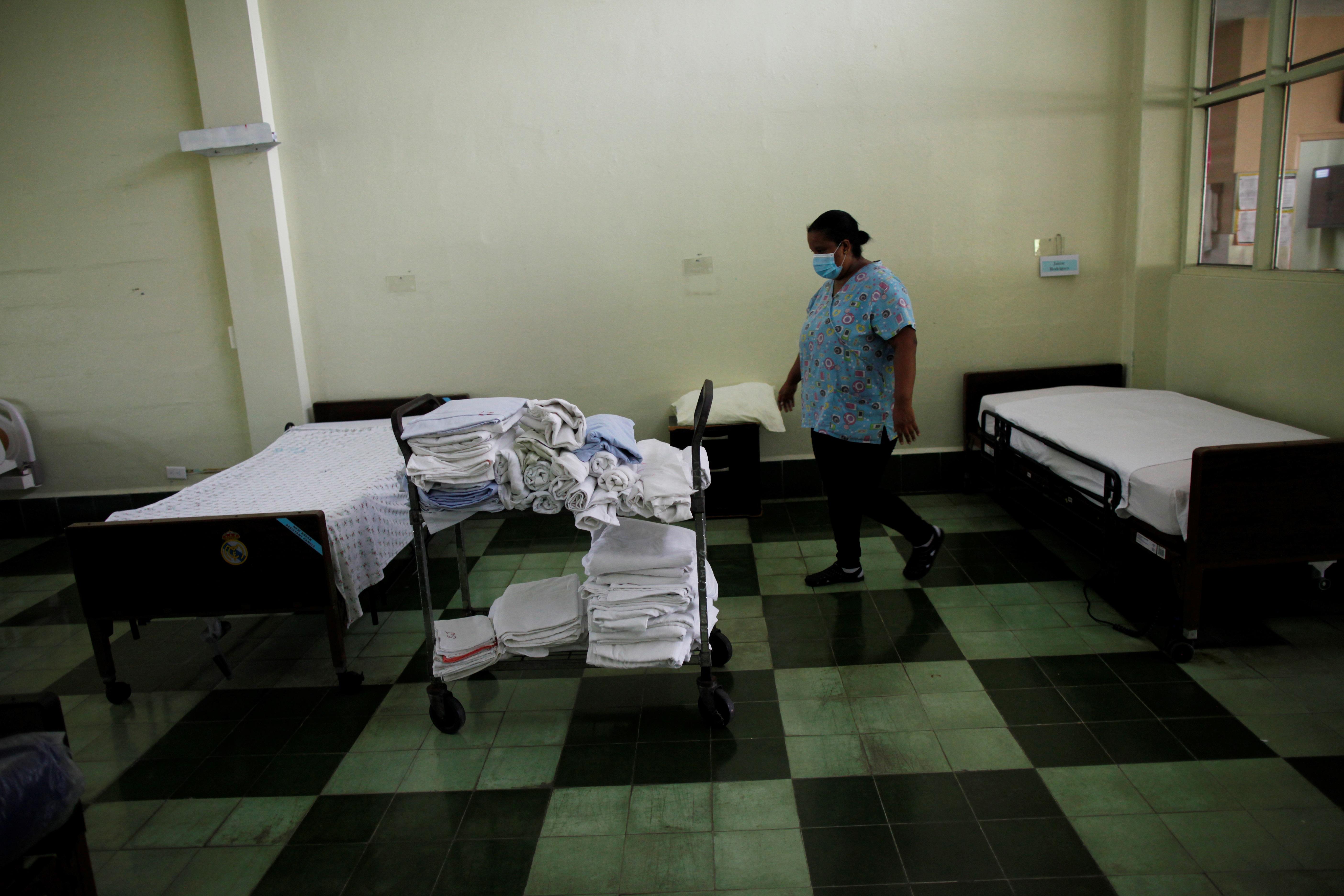 Natalia Murillo realiza limpieza en una de las habitaciones del asilo Hogar Bolívar en Ciudad de Panamá, durante la pandemia del nuevo coronavirus. (Foto Prensa Libre. EFE)