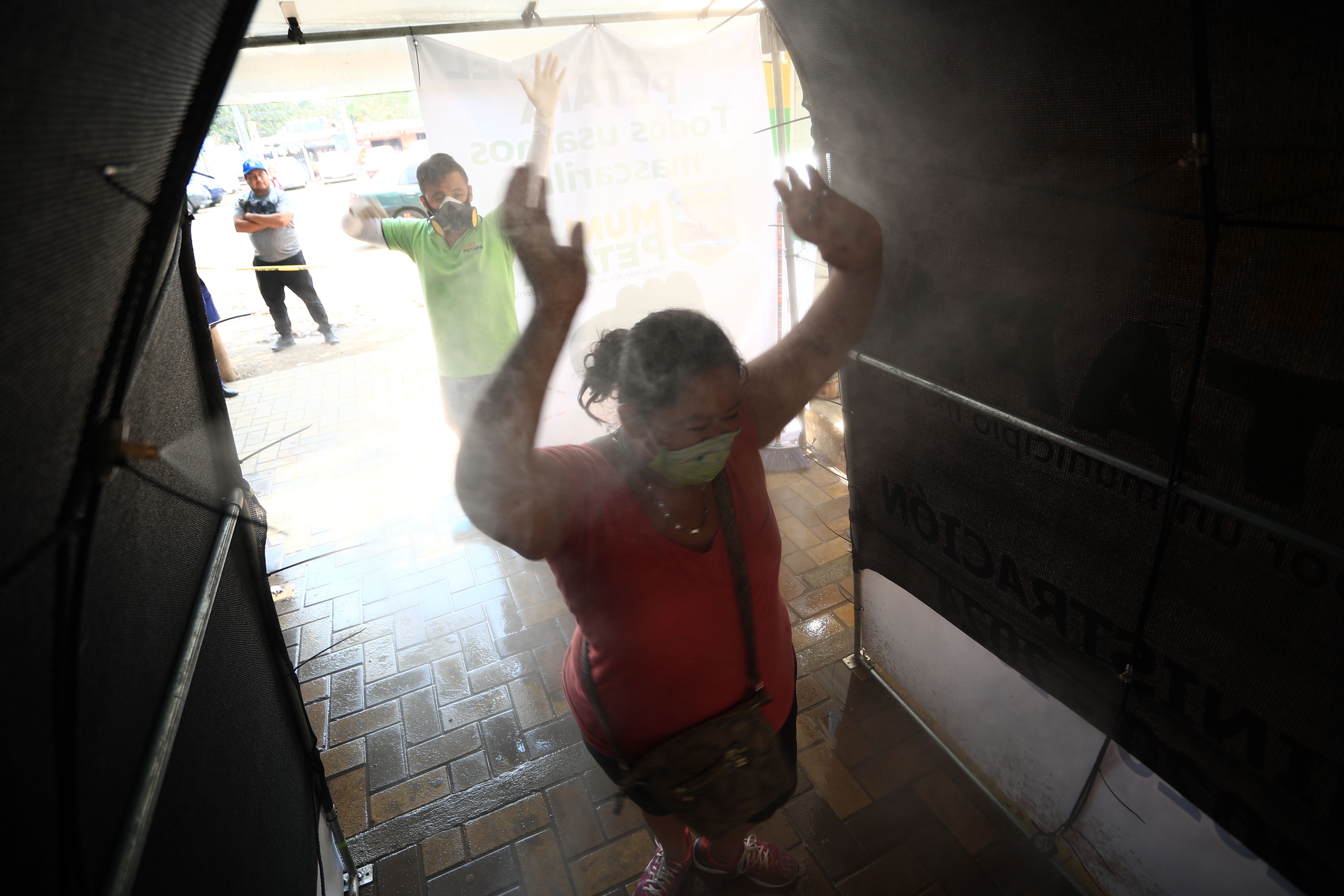 Una vecina pasa por el módulo de desinfección antes de entrar al mercado de la zona 1 de San Miguel Petapa. (Foto Prensa Libre: Carlos Hernández) 