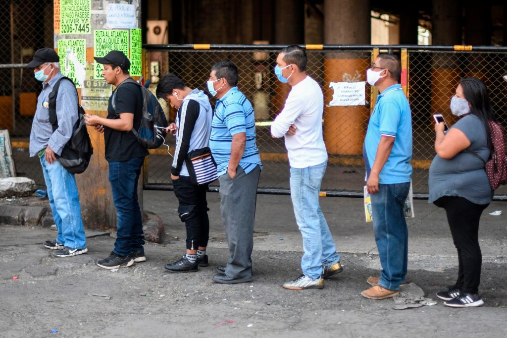  Personas hacen fila para subirse a un taxi, luego que se suspendió el servicio de transporte público en el país. Foto Prensa Libre: AFP 
