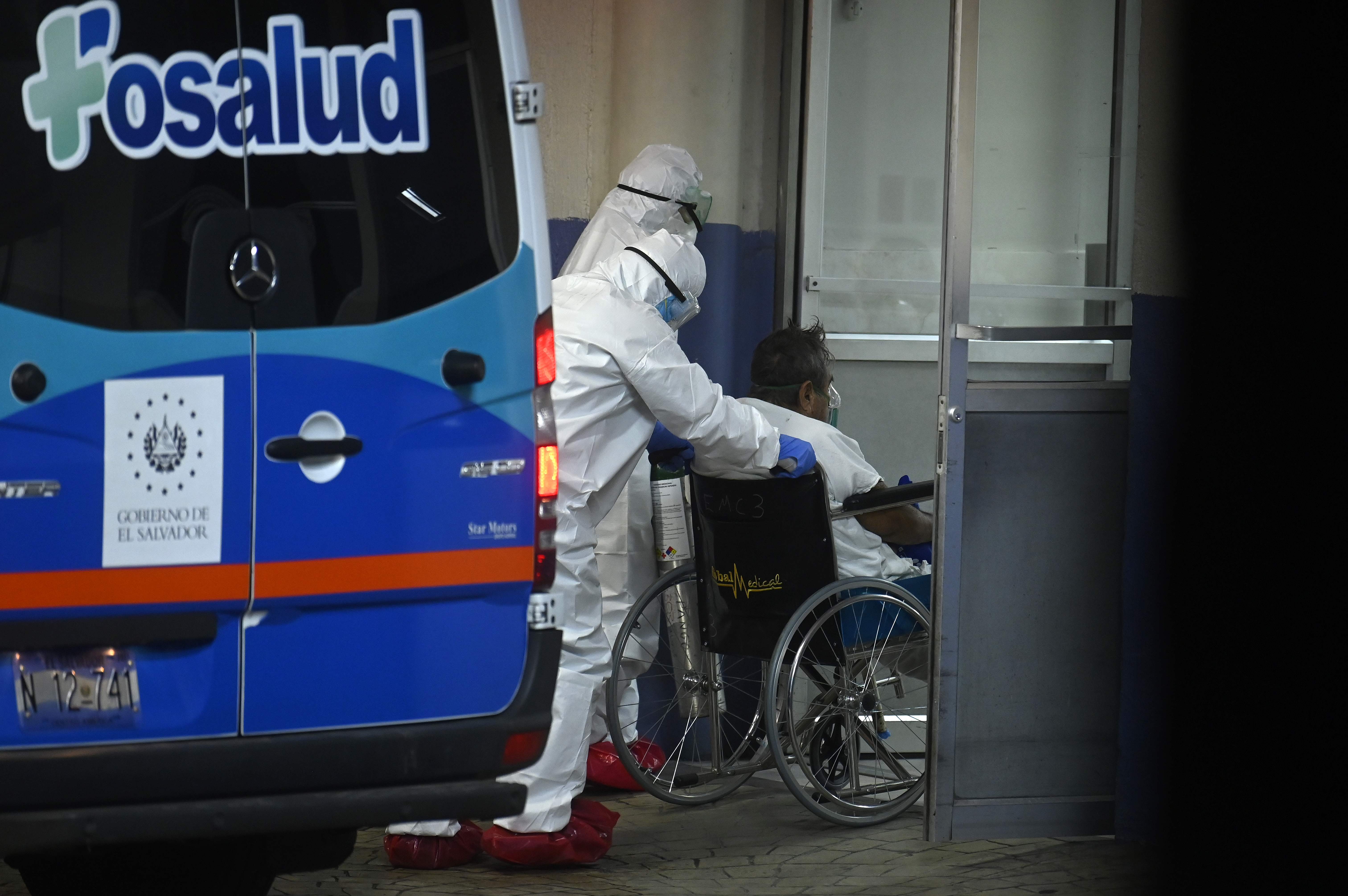 Personal médico lleva a un paciente infectado con el nuevo coronavirus en el hospital de Amatepec en San Salvador. (Foto Prensa Libre: AFP)
