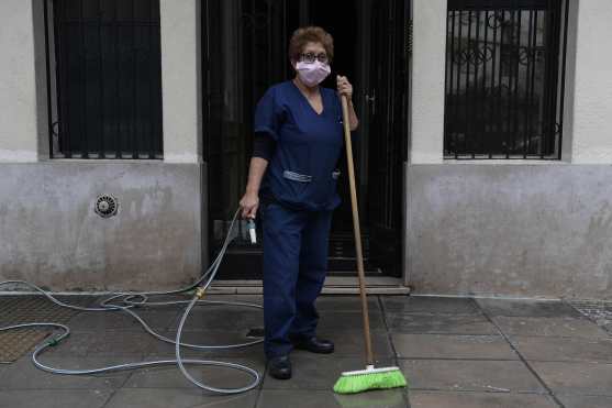 La argentina Elba Portales, de 59 años, a cargo de la limpieza de un condominio, posa para una foto en su lugar de trabajo durante el encierro impuesto por el gobierno contra la propagación del nuevo coronavirus, COVID-19, en Buenos Aires. Foto Prensa Libre: AFP
