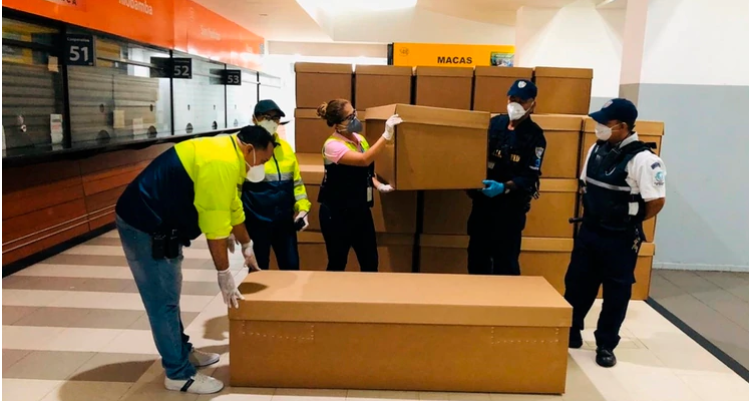 Trabajadores ordenan un cargamento de ataúdes de cartón, en Guayaquil, Ecuador. (Foto Prensa Libre: EFE)