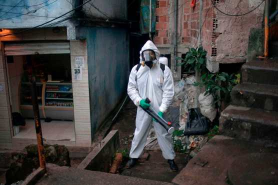  El brasileño Thiago Firmino, de 39 años, líder local, posa para una foto en un traje de protección mientras desinfecta la favela de Santa Marta en Río de Janeiro, Brasil, el 20 de abril de 2020 durante la pandemia de coronavirus COVID-19. Foto Prensa Libre: AFP
